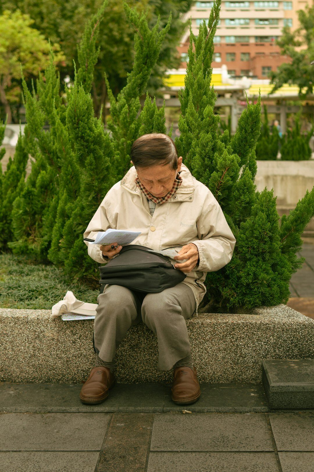 Senior man reading a newspaper on a park bench